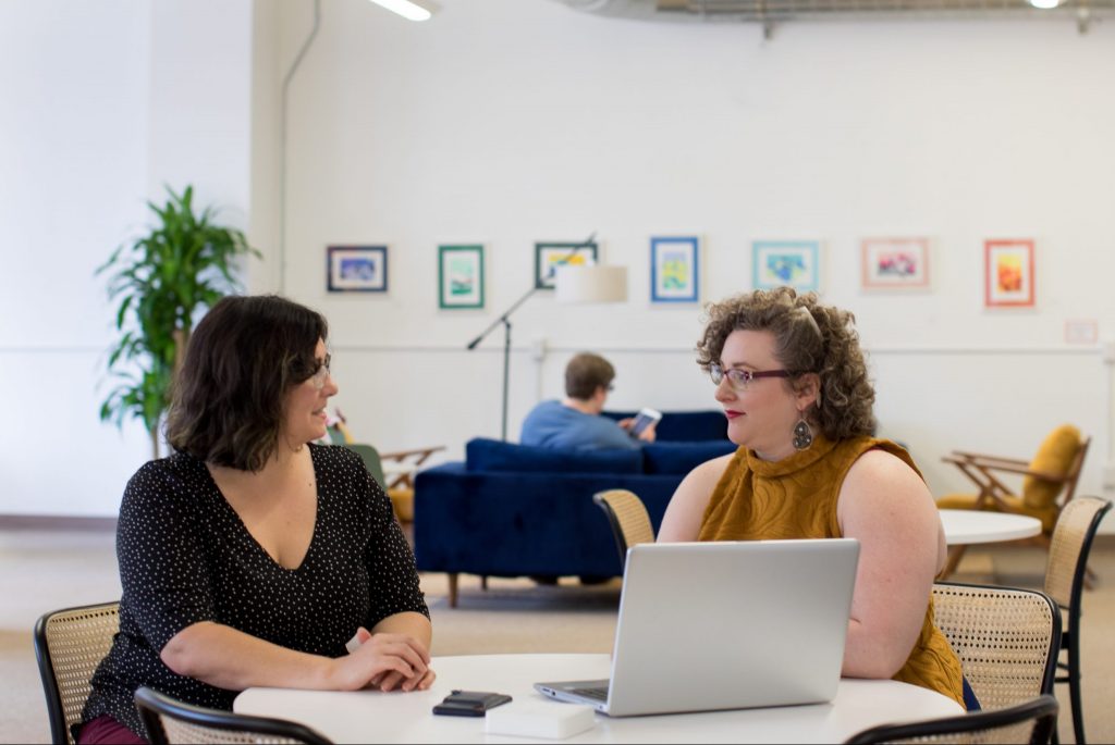 Two people seated engaged in business training.